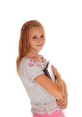 Image showing Schoolgirl holding her books to her chest.