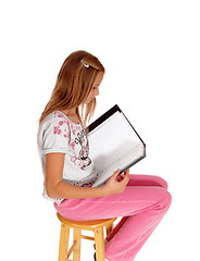 Image showing Schoolgirl writing in her schoolbook.