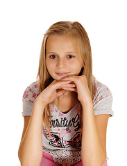 Image showing A sad looking young girl sitting on chair.