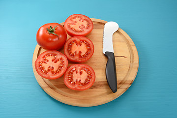 Image showing Whole tomato and halves with tomato knife 