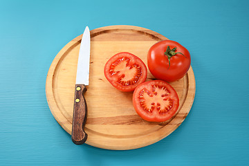 Image showing Whole and halved tomato with kitchen knife