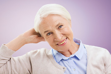 Image showing happy senior woman face over violet background