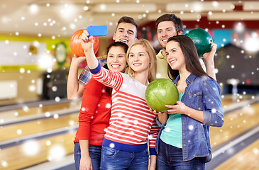 Image showing happy friends with smartphone in bowling club