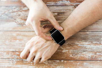 Image showing close up of male hands setting smart watch