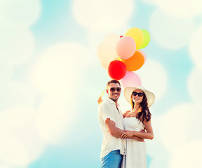 Image showing smiling couple with air balloons outdoors