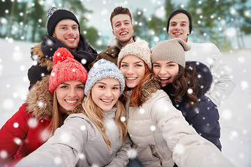 Image showing group of smiling friends taking selfie outdoors