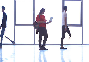 Image showing student girl standing with laptop, people group passing by