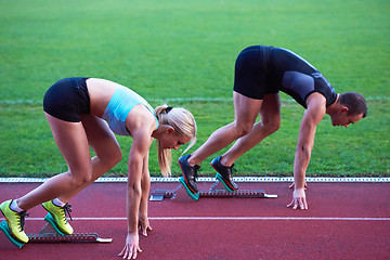 Image showing woman group  running on athletics race track from start