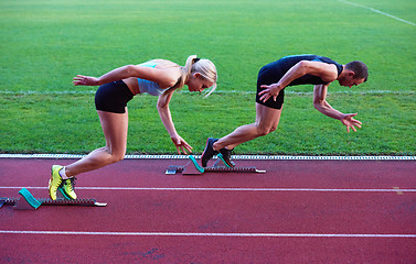 Image showing woman group  running on athletics race track from start