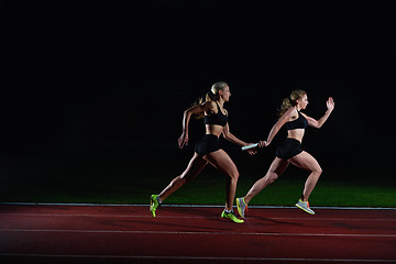 Image showing athletic runners passing baton in relay race