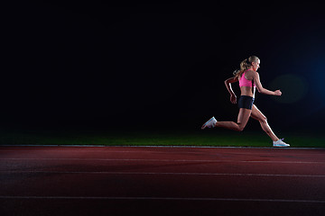 Image showing Athletic woman running on track