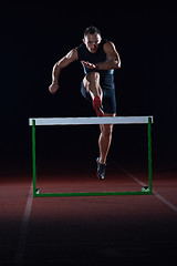 Image showing athlete jumping over a hurdles