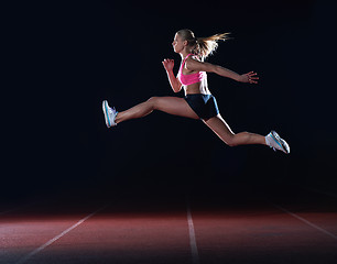 Image showing Athletic woman running on track