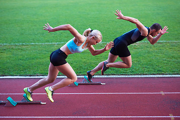 Image showing woman group  running on athletics race track from start