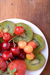 Image showing health fruit with cherry, strawberry, kiwi on wooden plate