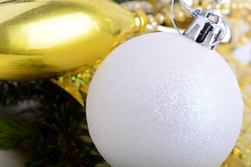 Image showing festive golden christmas decoration, candles, white balls, green fir tree branch, close up
