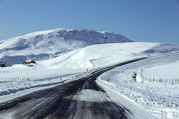 Image showing Snowy and slippery road with volcanic mountains in wintertime