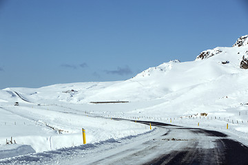 Image showing Snowy and slippery road with volcanic mountains in wintertime