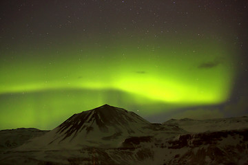 Image showing Northern lights with snowy mountains in the foreground