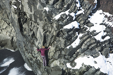 Image showing Woman climbing up basalt rocks, Iceland