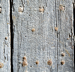 Image showing metal nail dirty stripped paint in the brown   red wood door and