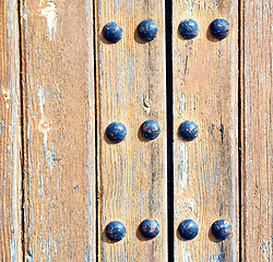 Image showing metal nail dirty stripped paint in the brown   red wood door and