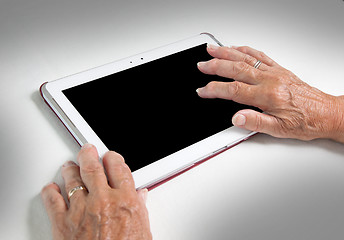 Image showing Hands of senior lady relaxing and reading the screen of her tabl