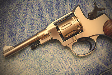 Image showing Nagan revolver on old blue jeans