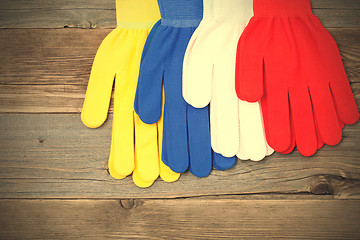 Image showing four gloves on old wood boards