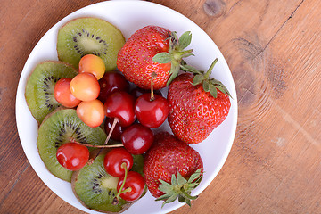 Image showing health fruit with cherry, strawberry, kiwi on wooden plate