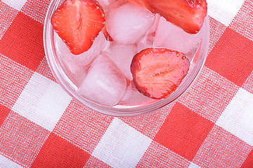 Image showing A slice of red strawberry on glass plate in party theme background