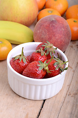 Image showing Bananas apple mandarin peach strawberry on wooden background as health food concept