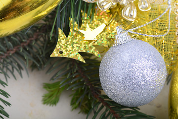 Image showing festive golden christmas decoration, candles, white balls, green fir tree branch, close up