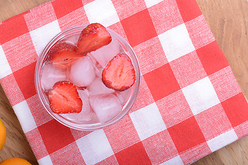 Image showing A slice of red strawberry on glass plate in party theme background