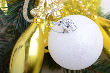 Image showing festive golden christmas decoration, candles, white balls, green fir tree branch, close up