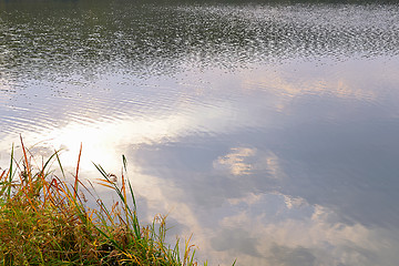 Image showing Autumn water background with reflection of clouds in water and g