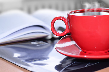 Image showing Red cup of coffee on the desk in the office