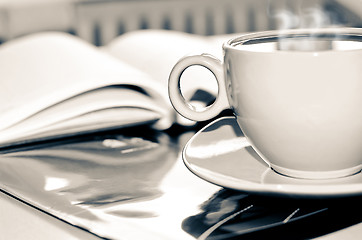 Image showing Cup of coffee on the desk in the office