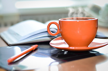 Image showing Cup of coffee on the desk in the office