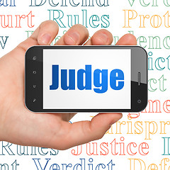 Image showing Law concept: Hand Holding Smartphone with Judge on display