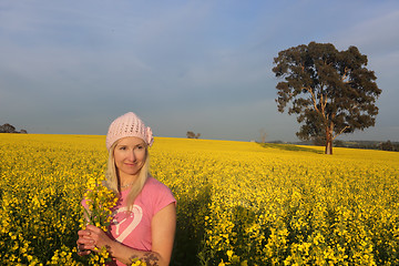 Image showing Woman standing in a field of golden canola farm