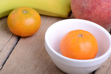 Image showing Bananas apple mandarin peach strawberry on wooden background as health food concept