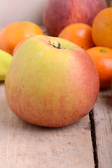 Image showing Bananas apple mandarin peach strawberry on wooden background as health food concept