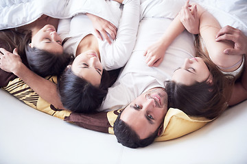 Image showing handsome man in bed with three beautiful woman