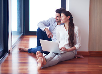 Image showing relaxed young couple working on laptop computer at home