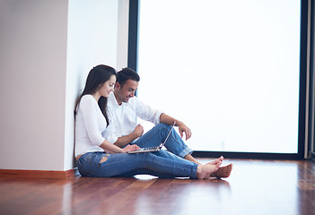 Image showing relaxed young couple working on laptop computer at home