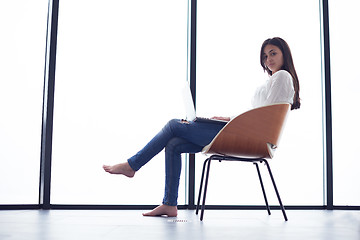 Image showing relaxed young woman at home working on laptop computer