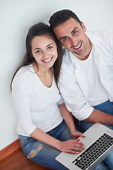 Image showing relaxed young couple working on laptop computer at home