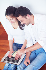 Image showing relaxed young couple working on laptop computer at home