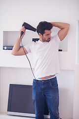 Image showing handsome man using  hairdryer